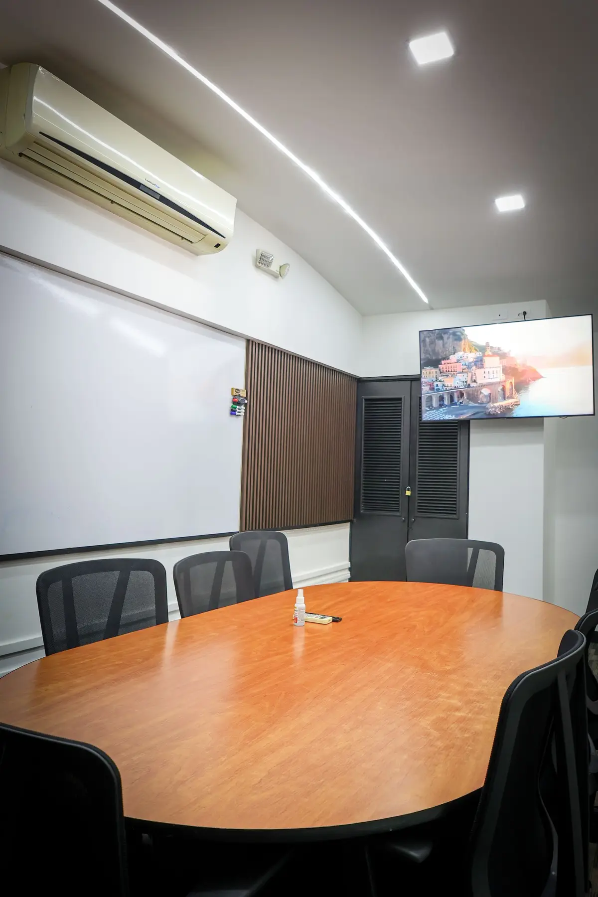 Sala de reuniones de Espacio 11, con mesa para ocho personas y pantalla.