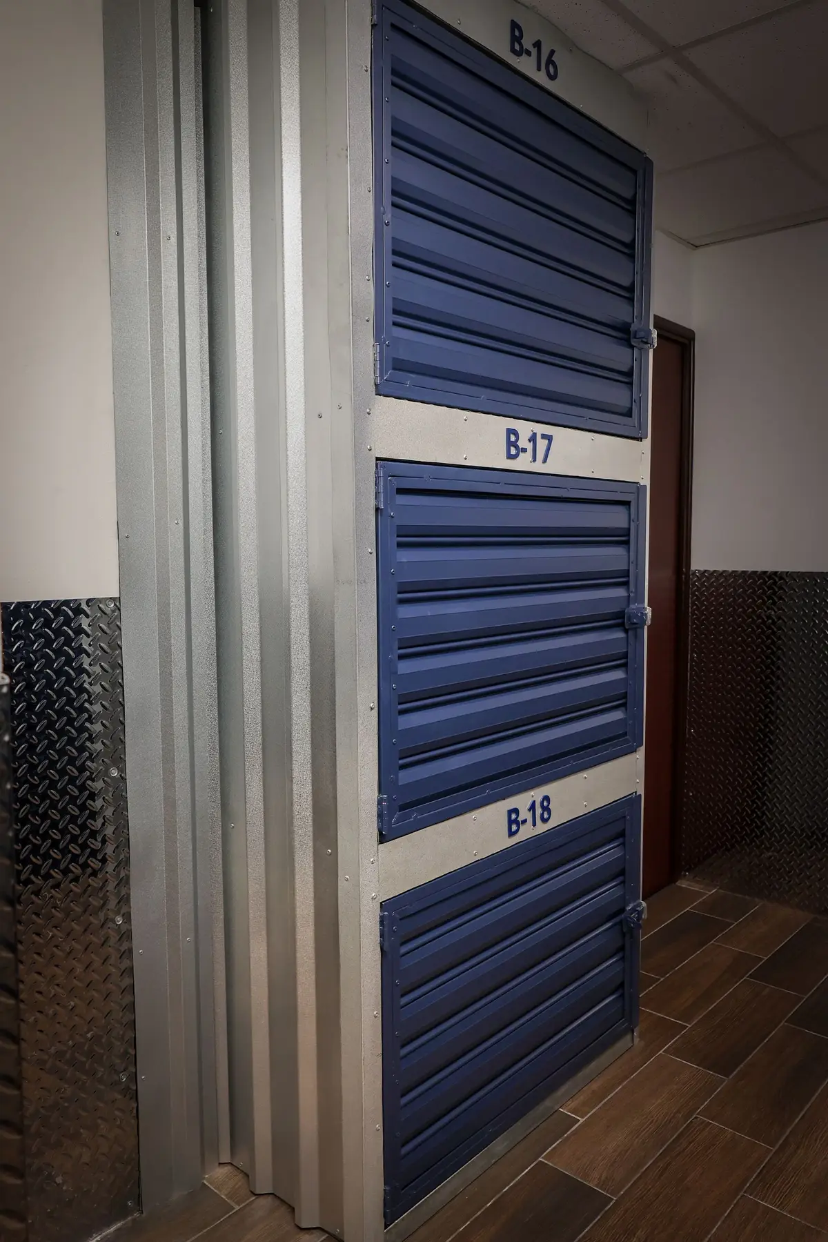 Detalle de puertas de bodega azules numeradas.